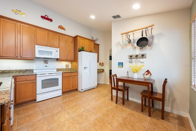 1646 Song Sparrow Ct, Sanford, FL 32773 - kitchen featuring white appliances, brown cabinetry, recessed lighting, stone countertops, and light tile patterned floors