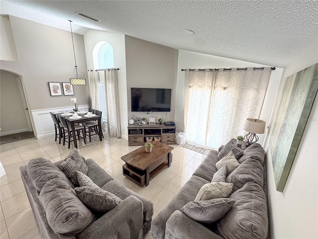 150 Barefoot Beach Way, Kissimmee, FL 34746 - living room with arched walkways, a textured ceiling, light tile patterned floors, and high vaulted ceiling