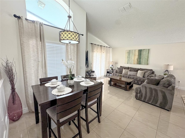 150 Barefoot Beach Way, Kissimmee, FL 34746 - dining area featuring lofted ceiling, healthy amount of natural light, a textured ceiling, and light tile patterned flooring