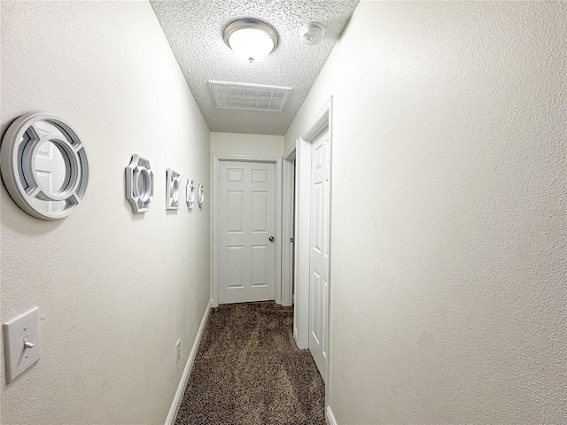 150 Barefoot Beach Way, Kissimmee, FL 34746 - hallway with dark colored carpet and a textured ceiling