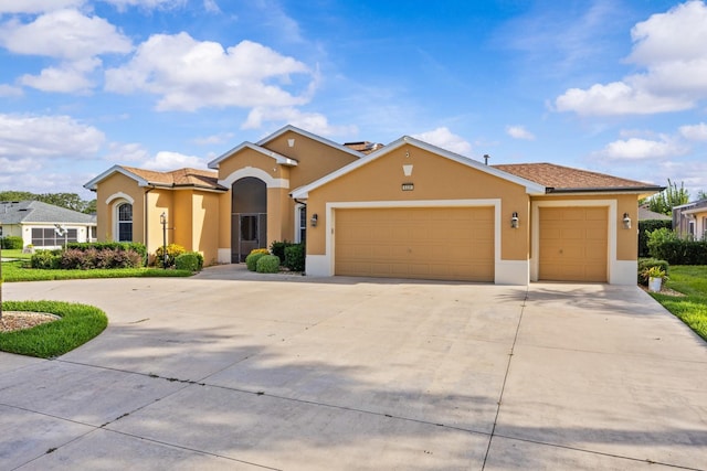 5339 Pond Crossing Pl, Leesburg, FL 34748 - view of front of home featuring a garage, concrete driveway, and stucco siding
