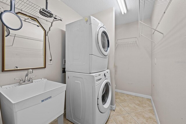 5339 Pond Crossing Pl, Leesburg, FL 34748 - laundry room featuring stacked washing machine and dryer and light tile patterned floors