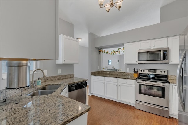 2935 Canoe Cir, Saint Cloud, FL 34772 - kitchen featuring stainless steel appliances, white cabinetry, light stone countertops, light wood-style flooring, and a chandelier