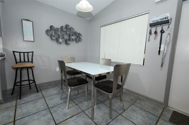 5027 Vineland Rd Unit 5027, Orlando, FL 32811 - tiled dining room featuring vaulted ceiling and baseboards
