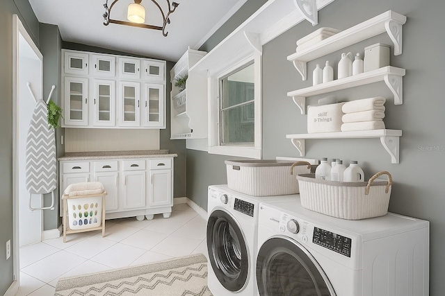 3417 Pershing Ave, Orlando, FL 32812 - washroom with washing machine and dryer, light tile patterned floors, and cabinet space