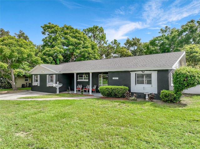 3417 Pershing Ave, Orlando, FL 32812 - ranch-style home with a front lawn, a shingled roof, covered porch, and stucco siding