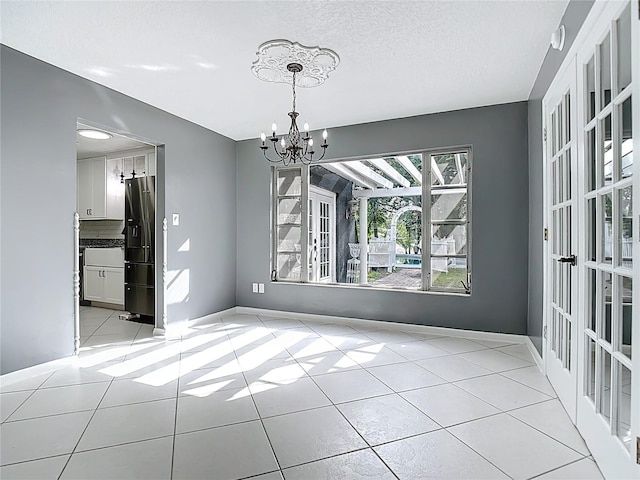 3417 Pershing Ave, Orlando, FL 32812 - unfurnished dining area featuring a chandelier, light tile patterned floors, and a textured ceiling