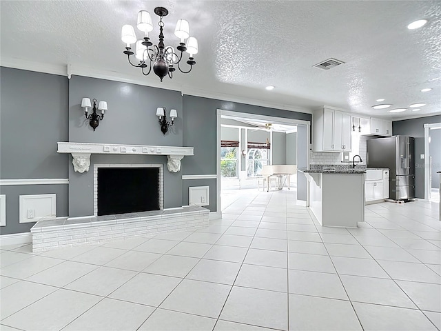 3417 Pershing Ave, Orlando, FL 32812 - kitchen with stainless steel fridge with ice dispenser, a textured ceiling, recessed lighting, open floor plan, and light tile patterned floors