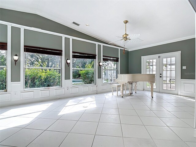 3417 Pershing Ave, Orlando, FL 32812 - tiled empty room with vaulted ceiling, a ceiling fan, a decorative wall, wainscoting, and french doors