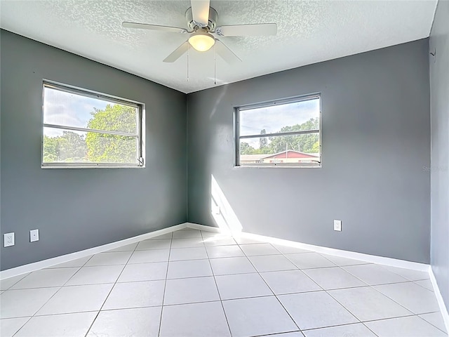 3417 Pershing Ave, Orlando, FL 32812 - empty room featuring a textured ceiling, healthy amount of natural light, a ceiling fan, and light tile patterned floors
