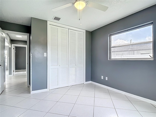 3417 Pershing Ave, Orlando, FL 32812 - unfurnished bedroom featuring a closet, light tile patterned floors, a ceiling fan, and a textured ceiling