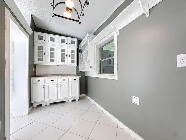 3417 Pershing Ave, Orlando, FL 32812 - kitchen with white cabinetry, light tile patterned floors, glass insert cabinets, and lofted ceiling