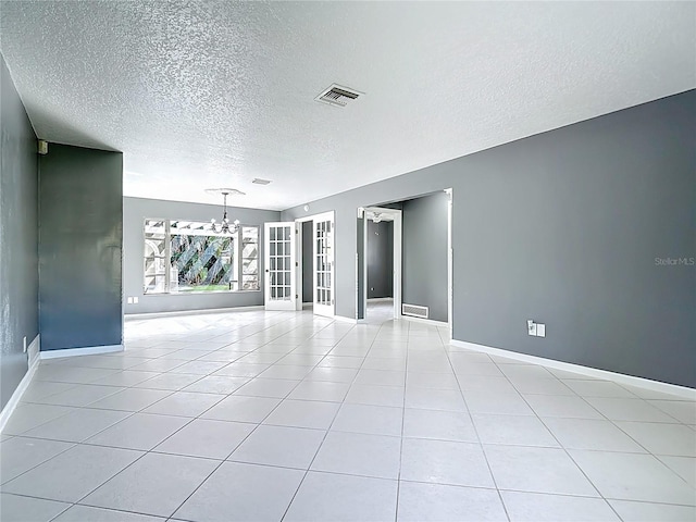 3417 Pershing Ave, Orlando, FL 32812 - empty room with a chandelier, a textured ceiling, and light tile patterned flooring