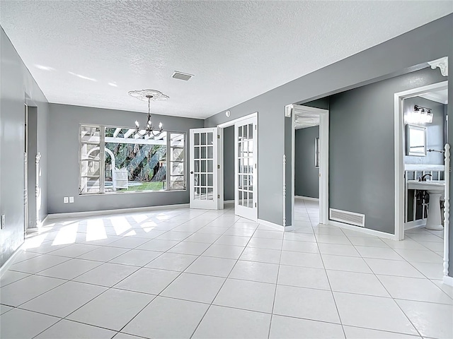3417 Pershing Ave, Orlando, FL 32812 - unfurnished dining area featuring a chandelier, light tile patterned floors, a textured ceiling, and french doors