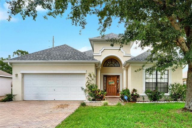 501 Lake Cummings Way, Lake Alfred, FL 33850 - view of front of property with stucco siding, decorative driveway, a front lawn, and a garage