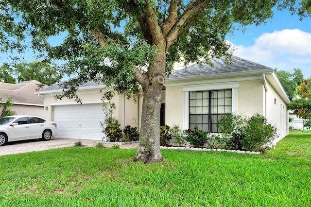 501 Lake Cummings Way, Lake Alfred, FL 33850 - view of front facade featuring a front yard, an attached garage, stucco siding, a shingled roof, and driveway