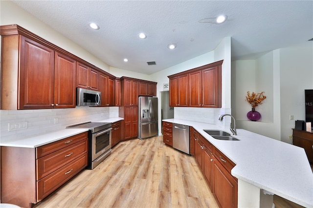 604 Timberwilde Ct, Winter Springs, FL 32708 - kitchen with stainless steel appliances, a peninsula, light wood-style flooring, recessed lighting, and backsplash