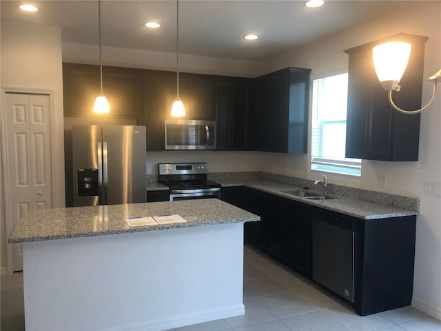 1003 E 10th St, Apopka, FL 32703 - kitchen with appliances with stainless steel finishes, a kitchen island, light stone counters, dark cabinetry, and recessed lighting