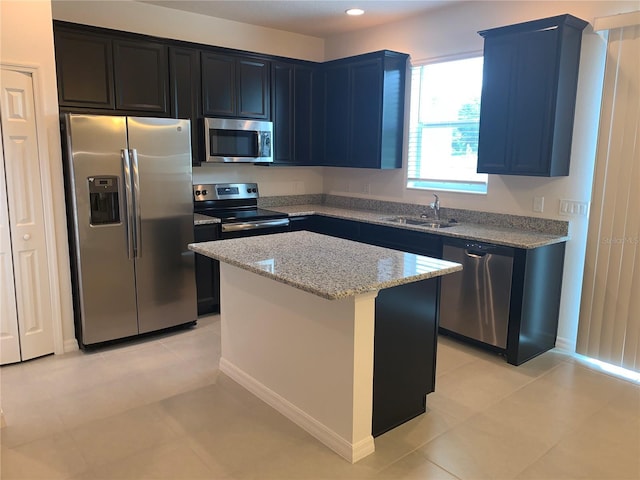 1003 E 10th St, Apopka, FL 32703 - kitchen featuring appliances with stainless steel finishes, light stone counters, a kitchen island, light tile patterned floors, and recessed lighting