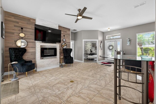 533 Quail Down Dr, Debary, FL 32713 - living area featuring a stone fireplace, a ceiling fan, and wooden walls