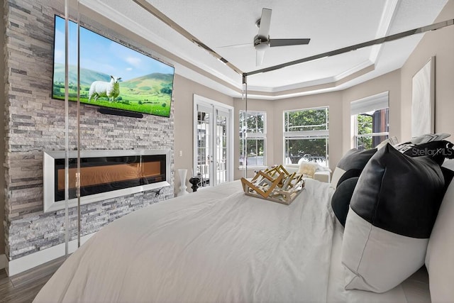 533 Quail Down Dr, Debary, FL 32713 - bedroom with a tray ceiling, a fireplace, wood finished floors, access to exterior, and ornamental molding