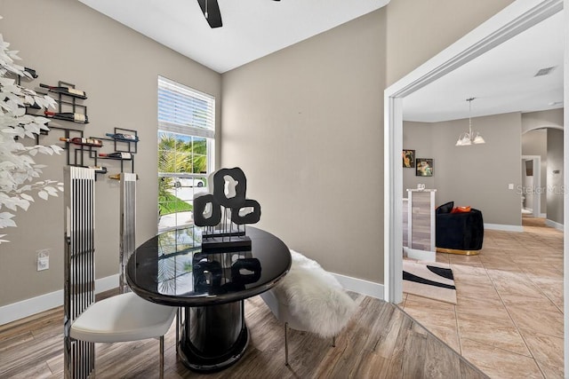 533 Quail Down Dr, Debary, FL 32713 - dining area featuring ceiling fan, arched walkways, a chandelier, and wood finished floors