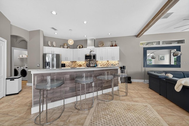 533 Quail Down Dr, Debary, FL 32713 - kitchen with appliances with stainless steel finishes, separate washer and dryer, tasteful backsplash, white cabinetry, and light countertops