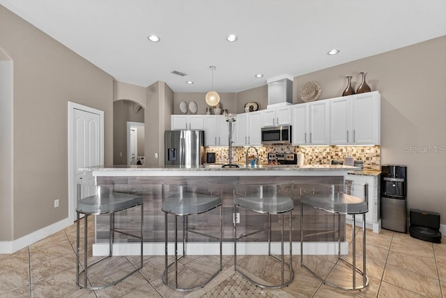 533 Quail Down Dr, Debary, FL 32713 - kitchen with appliances with stainless steel finishes, tasteful backsplash, white cabinets, arched walkways, and recessed lighting