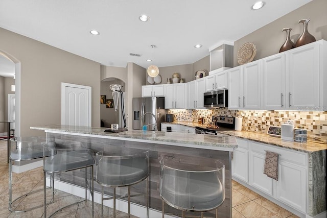 533 Quail Down Dr, Debary, FL 32713 - kitchen featuring arched walkways, appliances with stainless steel finishes, backsplash, white cabinets, and recessed lighting