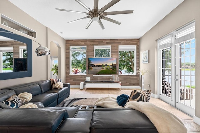 533 Quail Down Dr, Debary, FL 32713 - tiled living area with an accent wall, a ceiling fan, plenty of natural light, wooden walls, and arched walkways