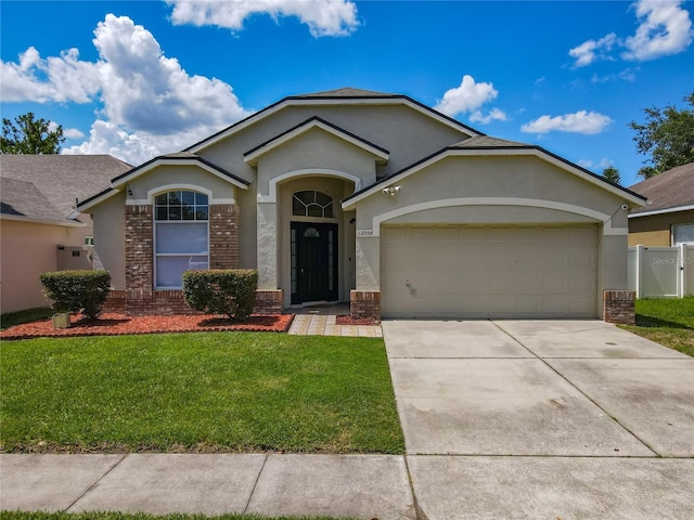 12938 Maribou Cir, Orlando, FL 32828 - ranch-style house featuring stucco siding, brick siding, an attached garage, concrete driveway, and a shingled roof