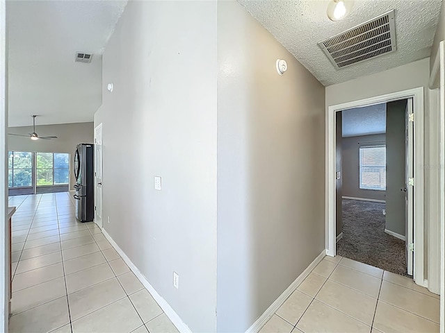 12938 Maribou Cir, Orlando, FL 32828 - hallway featuring a textured ceiling, light tile patterned floors, and healthy amount of natural light