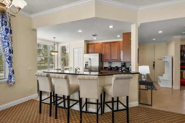 7509 Mourning Dove Cir Unit 204, Reunion, FL 34747 - kitchen with stainless steel fridge with ice dispenser, dark countertops, brown cabinetry, a peninsula, and carpet floors