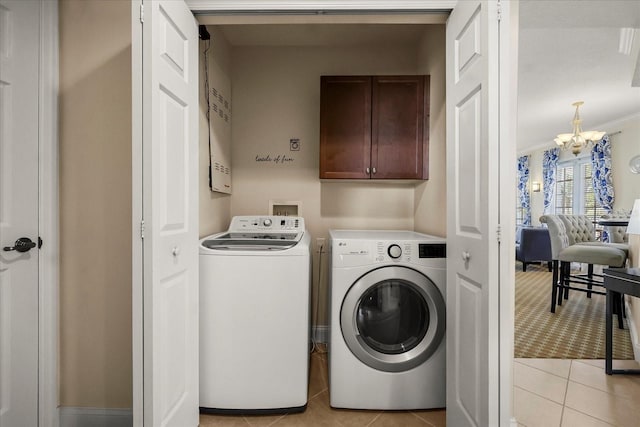 7509 Mourning Dove Cir Unit 204, Reunion, FL 34747 - washroom with cabinet space, washer and dryer, light tile patterned floors, and a chandelier