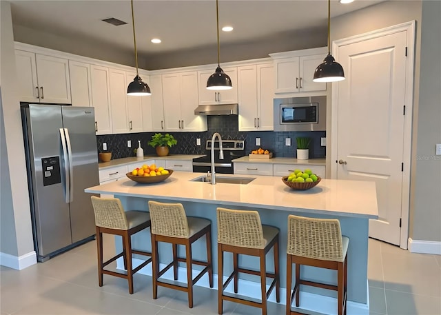 2729 Gabel Oak Dr, North Port, FL 34289 - kitchen with stainless steel appliances, under cabinet range hood, white cabinets, tasteful backsplash, and recessed lighting