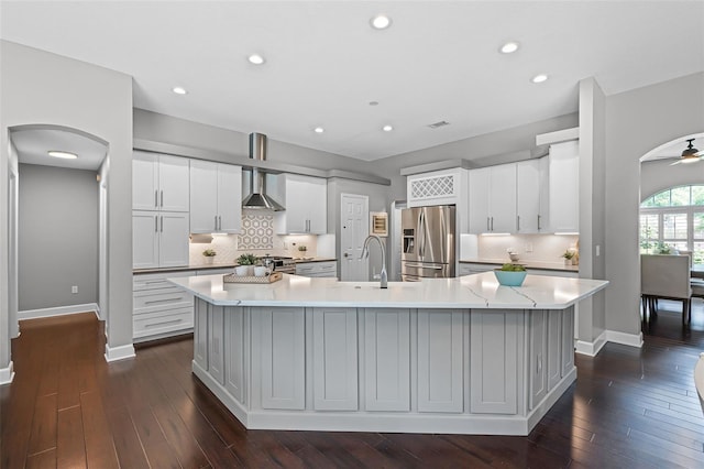 315 Lake Rd, Lake Mary, FL 32746 - kitchen with appliances with stainless steel finishes, a large island, light countertops, arched walkways, and backsplash