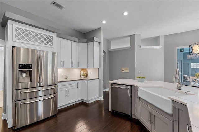 315 Lake Rd, Lake Mary, FL 32746 - kitchen with appliances with stainless steel finishes, dark wood finished floors, light stone counters, white cabinetry, and recessed lighting