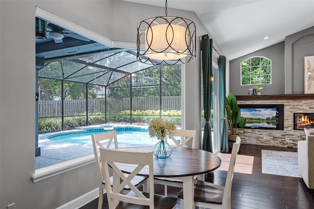 315 Lake Rd, Lake Mary, FL 32746 - dining space with hardwood / wood-style flooring, vaulted ceiling, a stone fireplace, and a sunroom