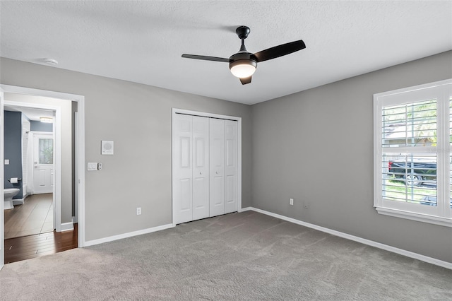 315 Lake Rd, Lake Mary, FL 32746 - unfurnished bedroom featuring multiple windows, carpet, a textured ceiling, a closet, and a ceiling fan