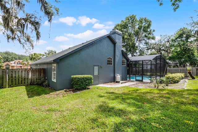 315 Lake Rd, Lake Mary, FL 32746 - back of property with stucco siding, a fenced backyard, a chimney, and glass enclosure