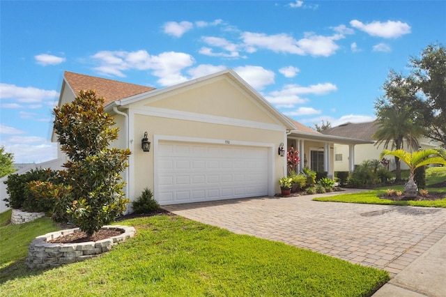 930 Willow Oak Loop, Minneola, FL 34715 - ranch-style house with decorative driveway, an attached garage, a front lawn, and stucco siding