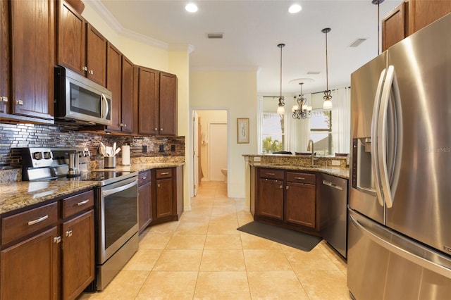 930 Willow Oak Loop, Minneola, FL 34715 - kitchen with appliances with stainless steel finishes, tasteful backsplash, a peninsula, a chandelier, and stone counters