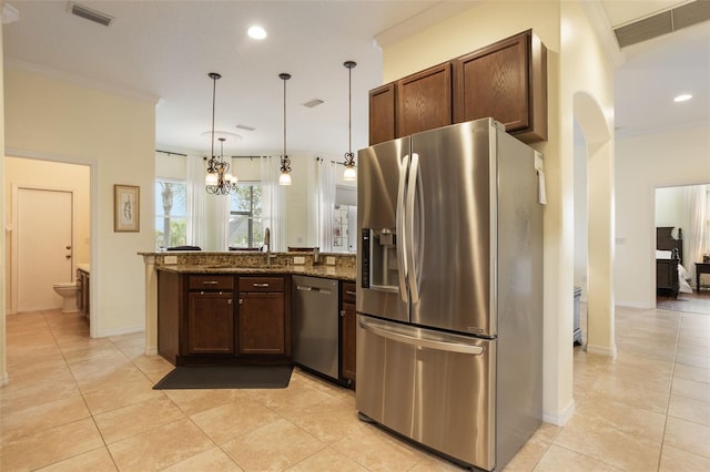 930 Willow Oak Loop, Minneola, FL 34715 - kitchen with stainless steel appliances, a peninsula, light tile patterned flooring, crown molding, and dark stone countertops