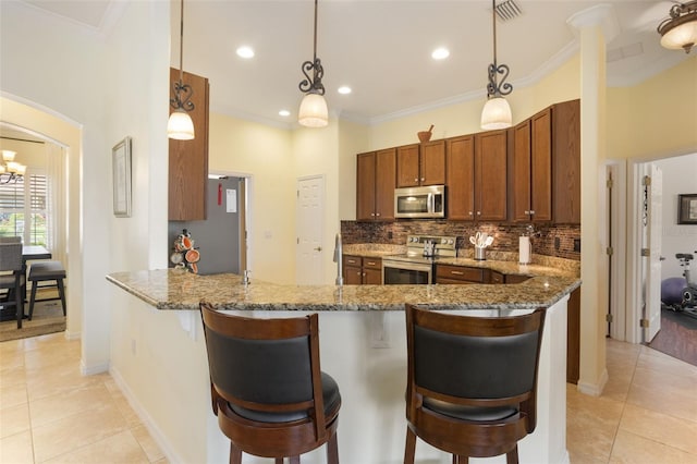 930 Willow Oak Loop, Minneola, FL 34715 - kitchen featuring stainless steel appliances, stone counters, light tile patterned floors, backsplash, and crown molding