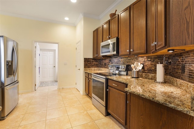 930 Willow Oak Loop, Minneola, FL 34715 - kitchen with stainless steel appliances, crown molding, backsplash, light tile patterned flooring, and stone counters