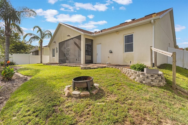 930 Willow Oak Loop, Minneola, FL 34715 - rear view of property featuring a sunroom, a fenced backyard, stucco siding, and a fire pit