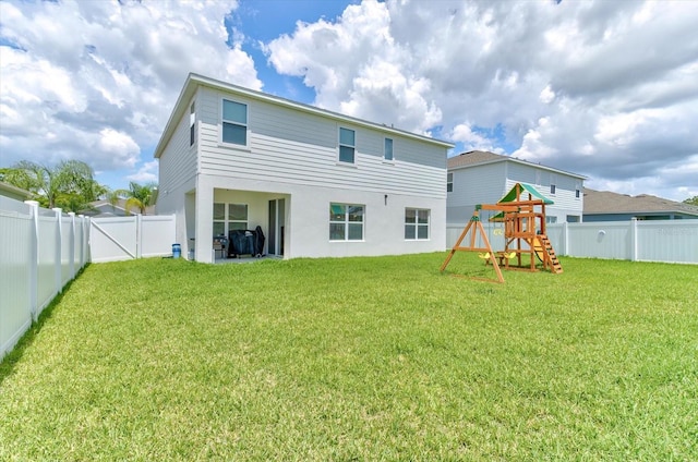2149 Tudor Rose Dr, Sanford, FL 32773 - rear view of house with a fenced backyard, a playground, and stucco siding