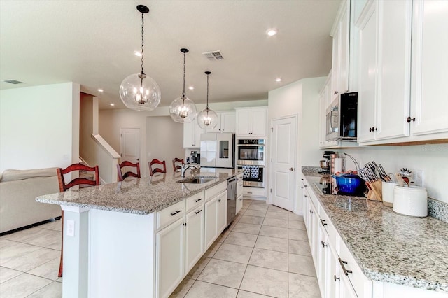 2149 Tudor Rose Dr, Sanford, FL 32773 - kitchen featuring appliances with stainless steel finishes, light tile patterned flooring, white cabinets, recessed lighting, and a kitchen breakfast bar