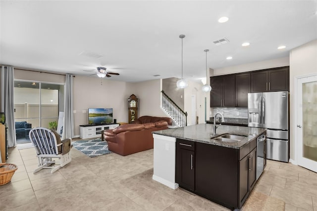 3472 Gretchen Dr, Ocoee, FL 34761 - kitchen featuring appliances with stainless steel finishes, dark stone counters, decorative backsplash, a ceiling fan, and dark brown cabinets