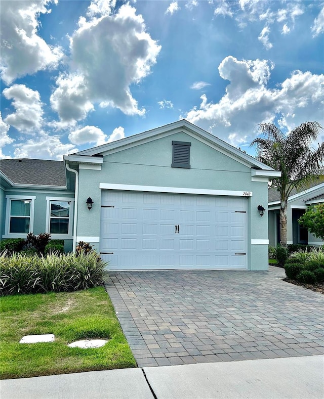 2042 Key Bay Trl, Kissimmee, FL 34747 - single story home with stucco siding, a garage, and decorative driveway